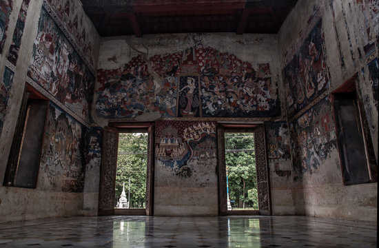 Within the church of Wat Kongkharam Rajavaravihara Temple (Photharam), Open old wooden door in temple and church wall tell the story of Buddhism.