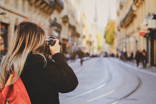 Selevtive on Photographer’s hand taking photo on street with tram rails and Saint Andre Cathedral in Bordeaux, France