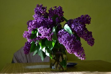 bouquet of bright lilacs in a jar on the table