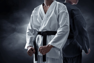 Two karate martial arts fighter on dark background