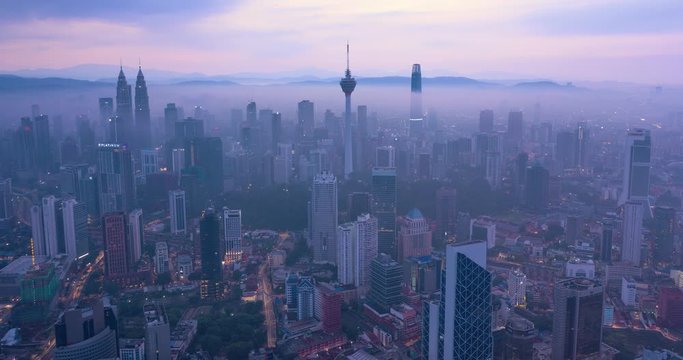 Night to day Aerial hyper lapse of Kuala Lumpur skyline covered with mist, Malaysia
