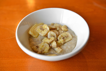 Organic oatmeal porridge with butter and dried bananas. Healthy breakfast and diet concept