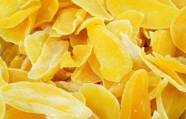 Dried mango background. Candied slices of mango fruit close-up. Oriental sweets for tea.