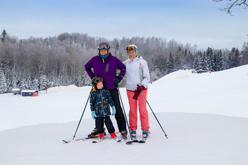 Middle aged couple on ski holiday in mountains. Older couple with grandson.