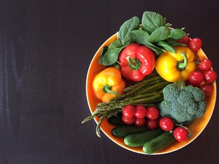 fresh  vegetables in a basket  on dark wooden table