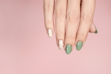 Closeup top view of beautiful hand of white woman isolated on pink pastel background. Fingernails with stylish trendy two colors faded manicure made with modern gel polish and silver stamping design.