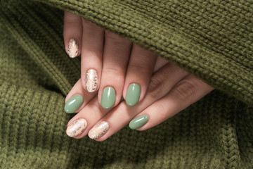 Closeup top view of beautiful two faded colors trendy manicure of green and pink nails with glossy...