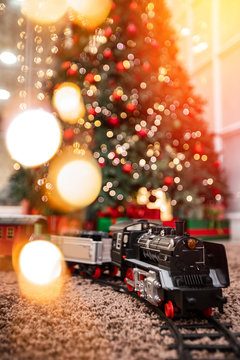 Christmas toy train with wagons in background illumination and New Year tree