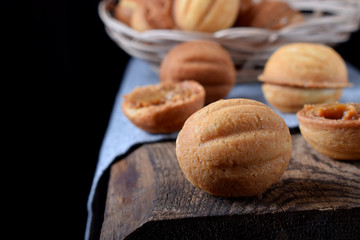 Walnut shaped cookies with condensed milk on wooden table