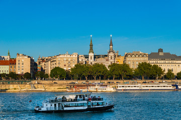 Budapest, Hungary - October 01, 2019: Cityscape of Budapest with Orthodox Cathedral of Our Lady with passenger boats on the Danube river, Budapest, Hungary.