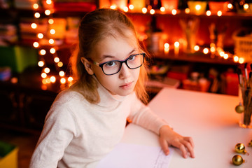 Small blonde child writes the letter to Santa