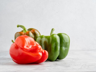 Colorful fresh peppers on white gray background