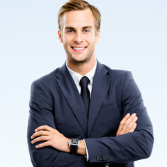 Portrait of smiling confident businessman in black confident suit, isolated over grey background....