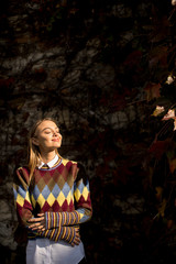 Young woman standing outside at sunny autumn day