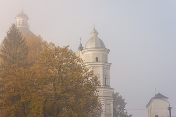 Catholic church in thick fog. Autumn morning in the city. Ukraine