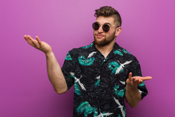 Young man wearing a vacation look doubting between two options.