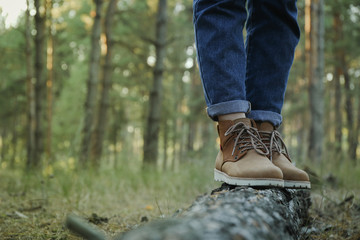 Person in boots and jeans on trunk, space for text