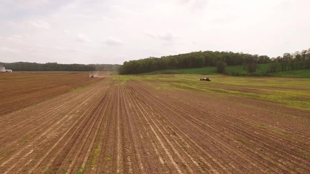 Tilt up aerial, tractor out in Indiana field