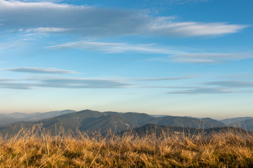 Fototapeta premium Beautiful sunset and layered mountain silhouettes in evening