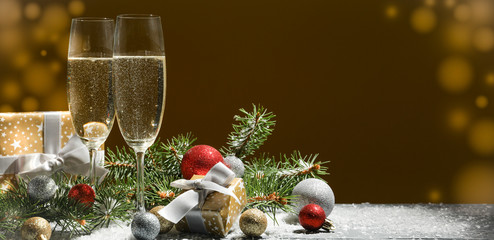 Champagne glasses and baubles against golden background, space for text © Atlas