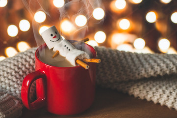Red mug with hot chocolate with melted marshmallow snowman