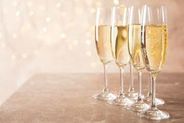Champagne glasses against blurred lights background, space for text