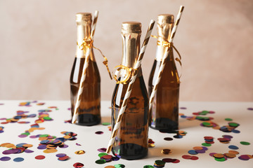Mini champagne bottles with straws on decorated background, close up - obrazy, fototapety, plakaty