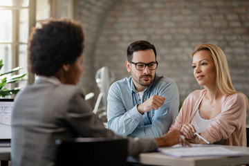 Couple communicating with their insurance agent on a meting in the office.