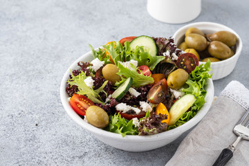 Salad of fresh vegetables and herbs with olives and feta cheese.