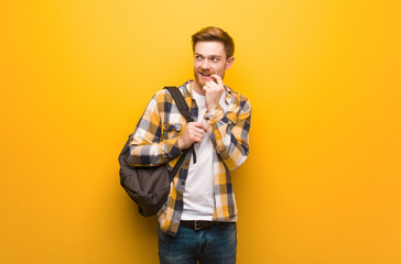 Fototapeta premium Young redhead student man relaxed thinking about something looking at a copy space