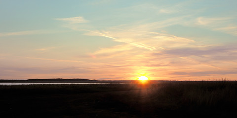 Fototapeta na wymiar Dawn on the lake in the summer. Sun rays and beautiful clouds...