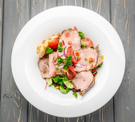 Salad leaves with sliced roast beef and sun-dried cherry tomatoes
