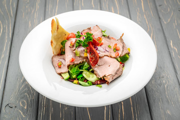 Salad leaves with sliced roast beef and sun-dried cherry tomatoes