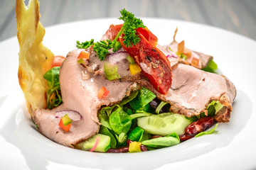 Salad leaves with sliced roast beef and sun-dried cherry tomatoes