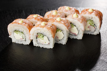 Sushi Rolls with cucumber, shrimp, crab meat and Cream Cheese inside on black slate isolated. Philadelphia roll sushi with shrimp. Sushi menu. Horizontal photo.