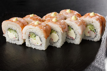 Sushi Rolls with cucumber, shrimp, crab meat and Cream Cheese inside on black slate isolated. Philadelphia roll sushi with shrimp. Sushi menu. Horizontal photo.