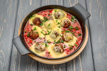 beef meatballs with tomato sauce and parmesan cheese in pan
