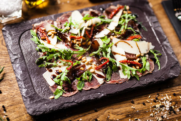 Beef carpaccio served on a board in restaurant