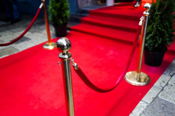 Red carpet at an exclusive event. Award ceremony red carpet and golden stanchions. Festive event or...