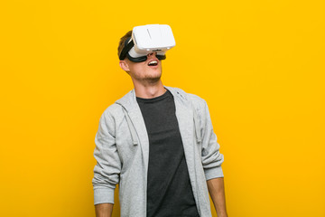 Young caucasian man using a virtual reality glasses