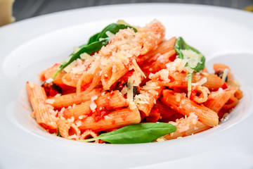 Penne pasta with shrimp and mussels, tomato sauce, basil and grated parmesan cheese