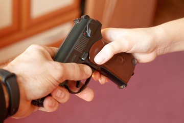 Adult man hands a gun to a child
