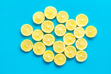 Lemon slices on blue background top view