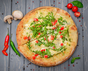 Traditional italian pizza with arugula on wooden background