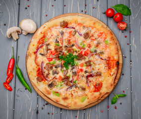 Traditional italian pizza with minced meat on wooden background