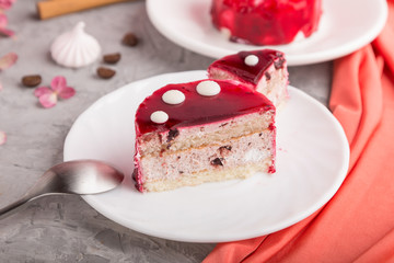 Sliced red cake with souffle cream with cup of coffee on a gray concrete  background. side view, selective focus.