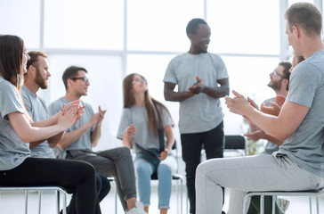 young woman standing in a circle of seminar listeners