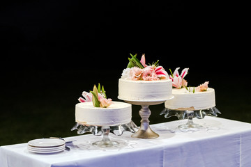 Three wedding cakes with a fresh lillium flower decoration.