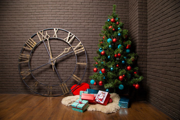 Christmas tree and gifts against a brick wall and watch dial