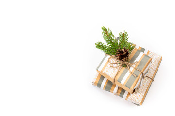 Gifts packed in craft paper on a white isolated background. Fir branches and cone. Copy space